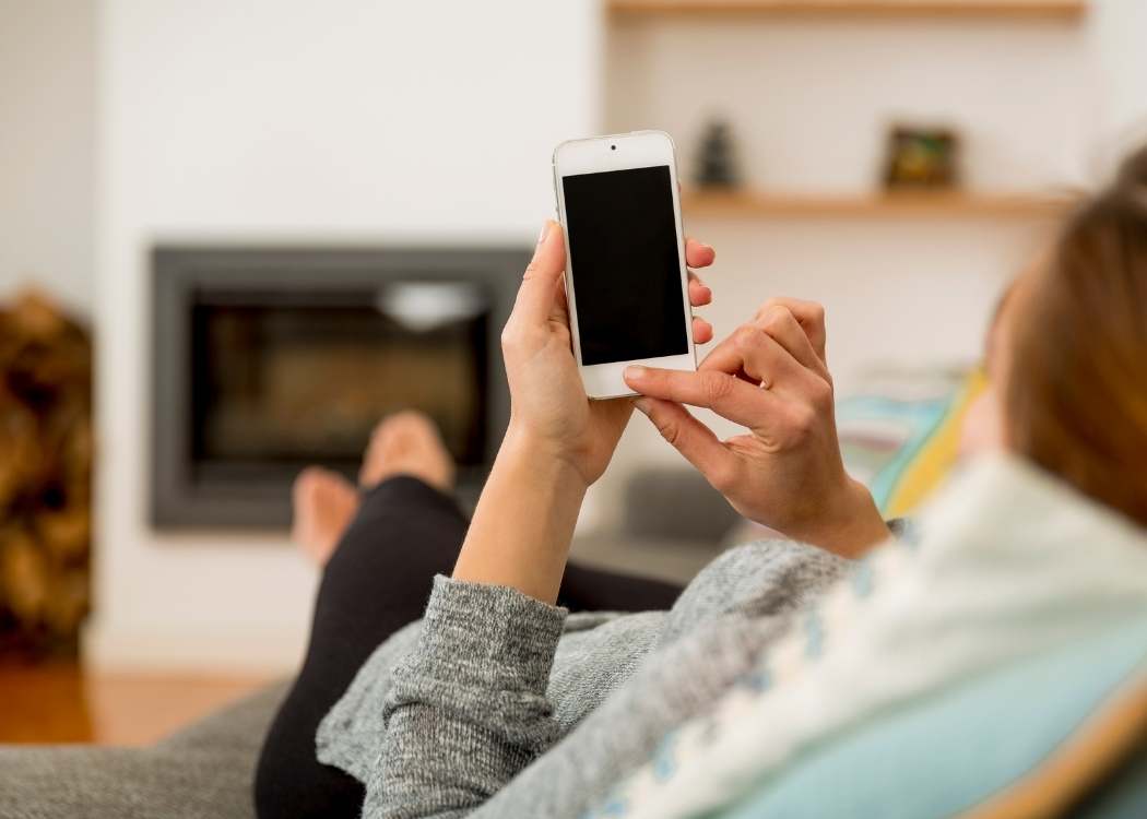 Woman sitting on a sofa holding a smart phone