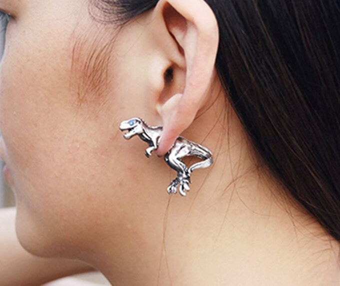 Close up of woman wearing dinosaur earrings