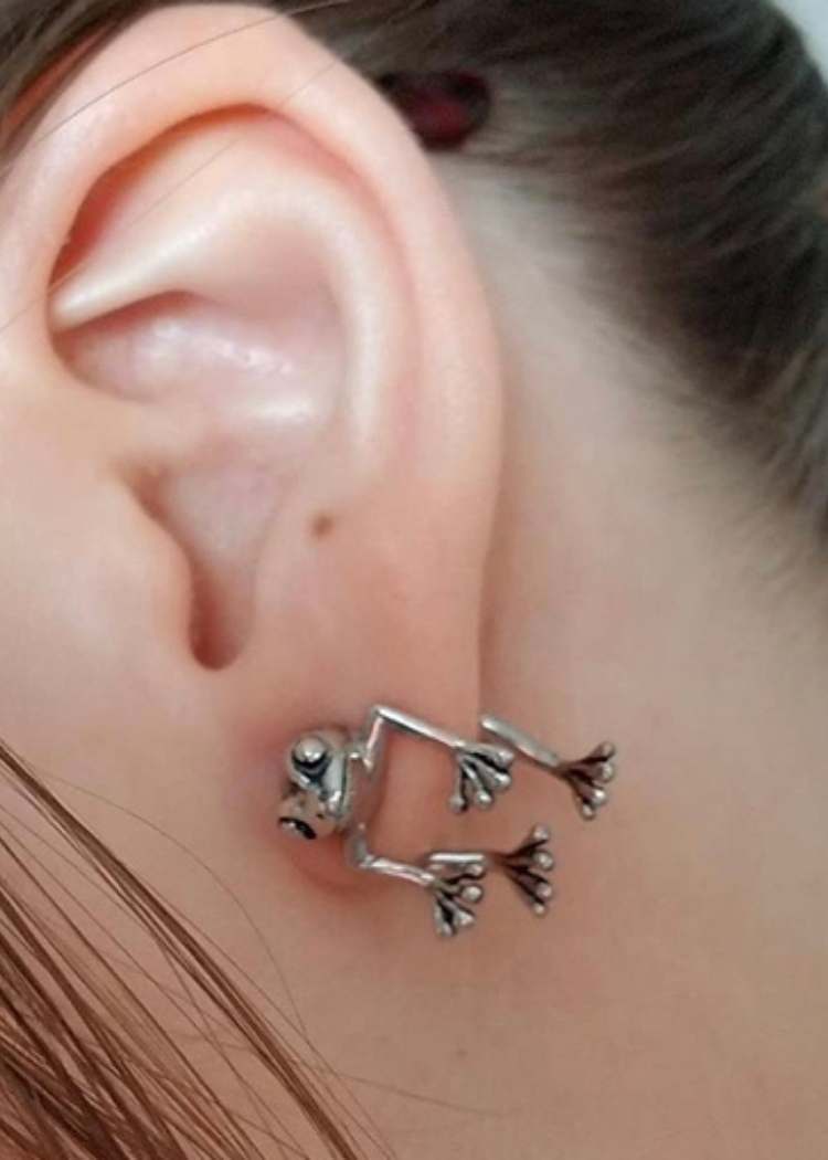 Close up of ear wearing silver frog earrings